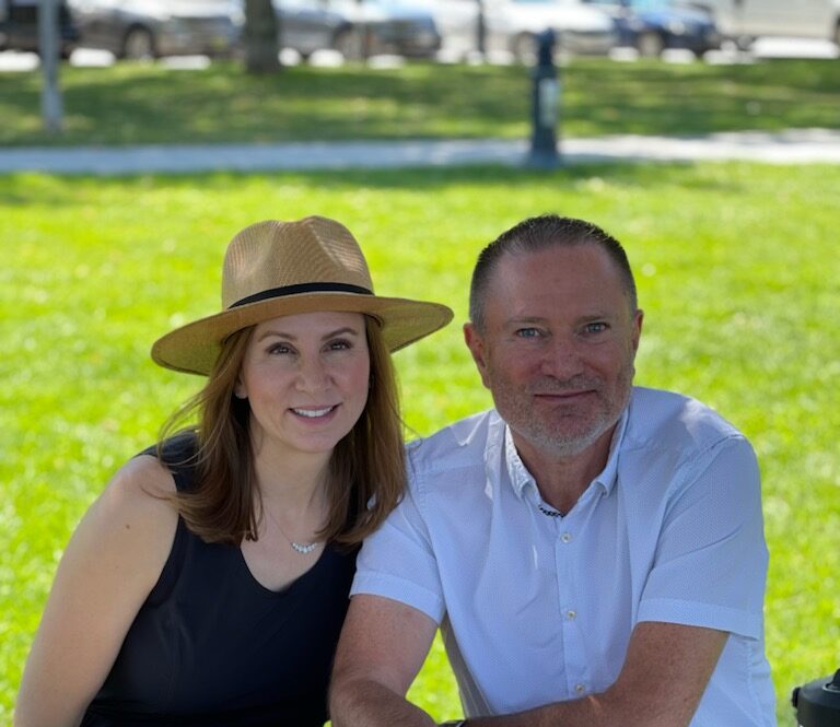 nathalie and robert sit outside in a park talking about linq flooring in vernon bc their flooring studio with a great vibe